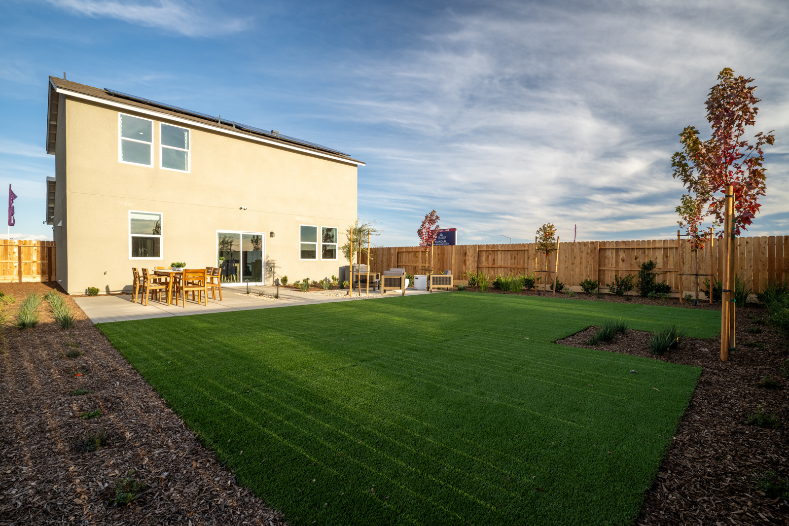 A backyard with a fence and a house.