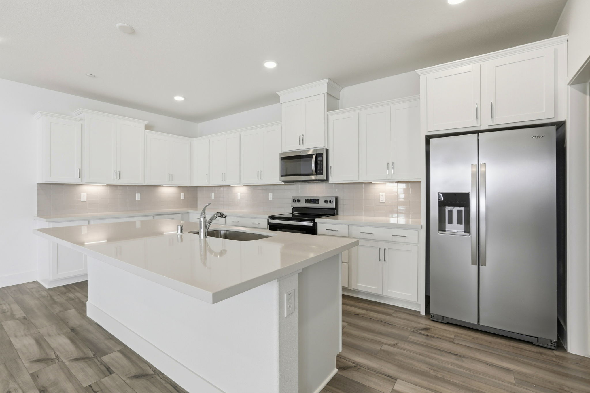 A kitchen with white cabinets.