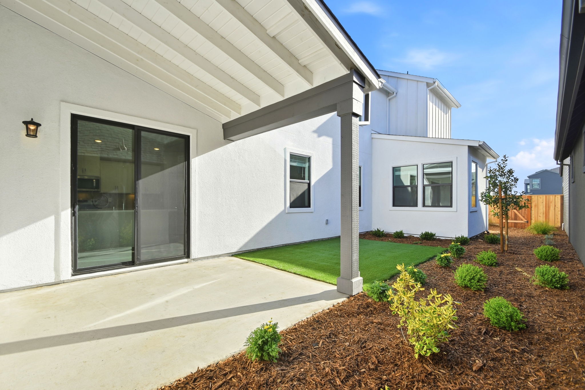 A white house with a green lawn.