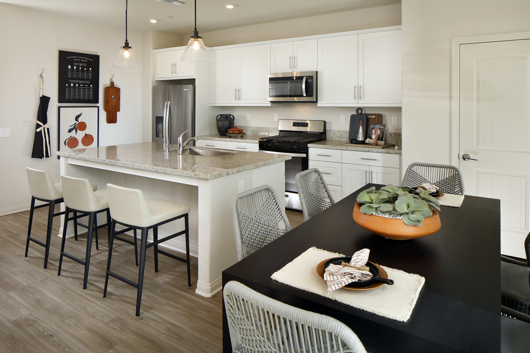 A kitchen with a table and chairs.