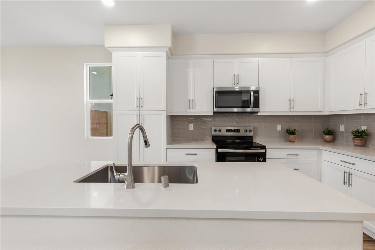 A kitchen with white cabinets.