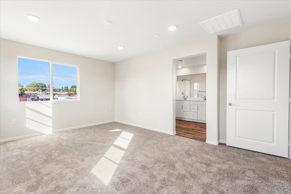 A large empty room with white cabinets.