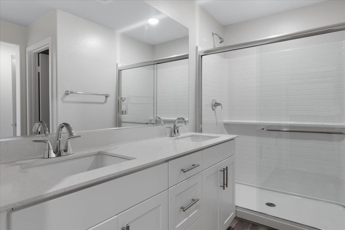 A bathroom with a shower unit and sink.