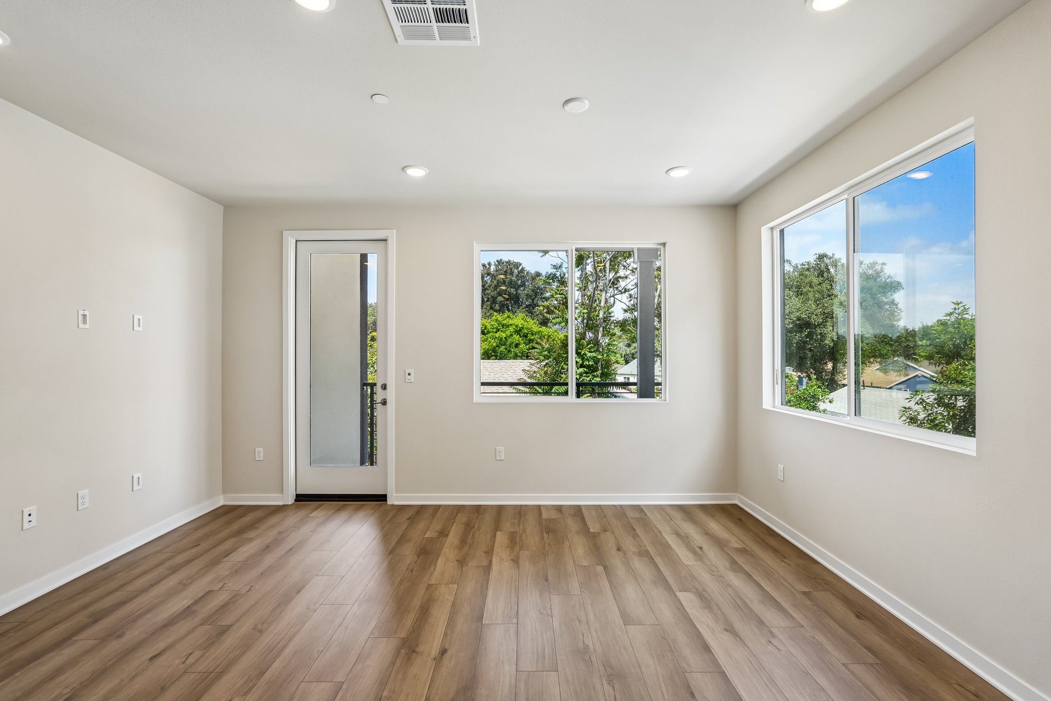 A room with a wood floor and windows.
