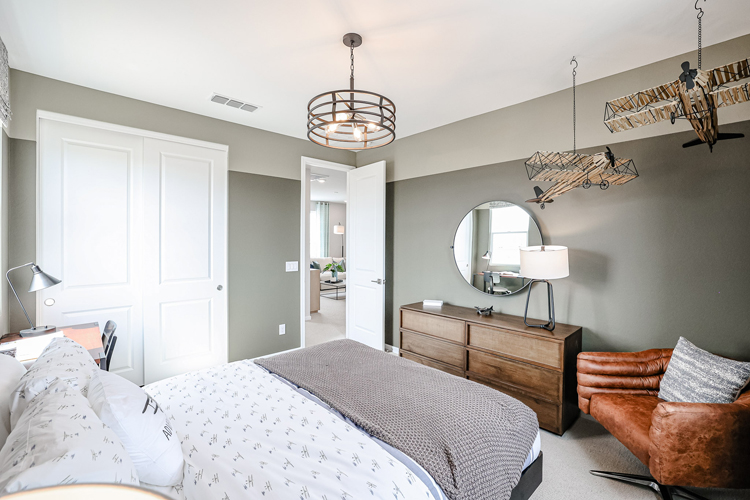 A bedroom with a bed and a mirror.