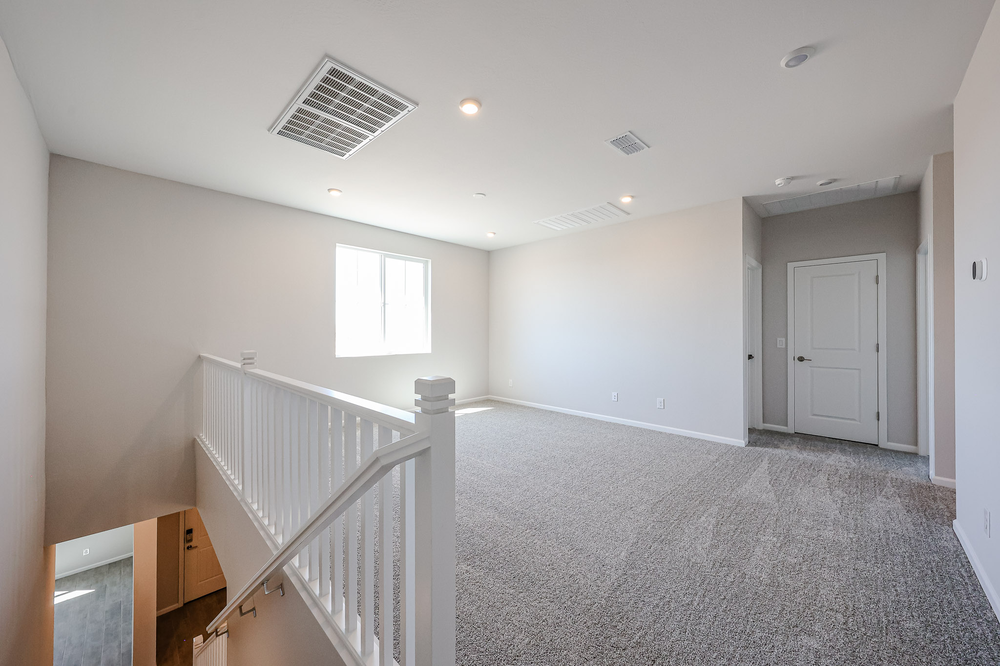 A room with white walls and a white railing.
