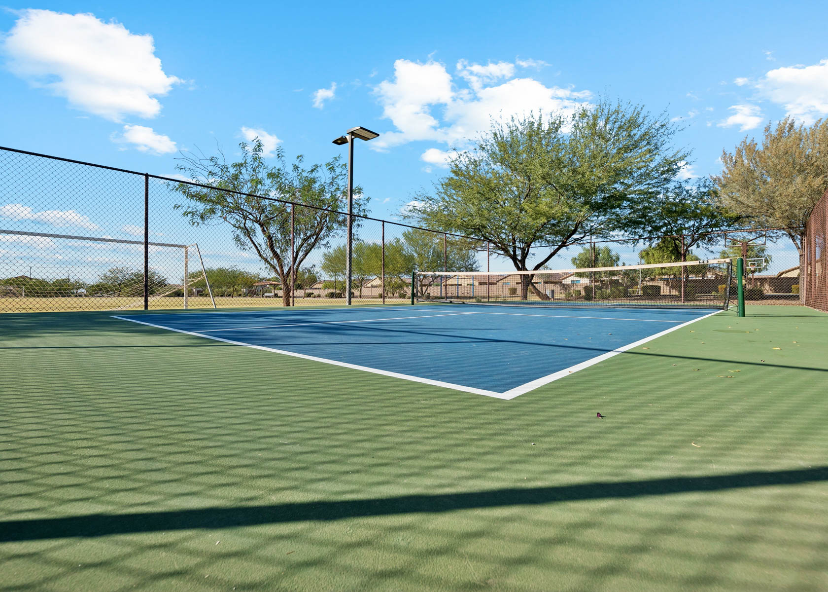 A tennis court with a fence.