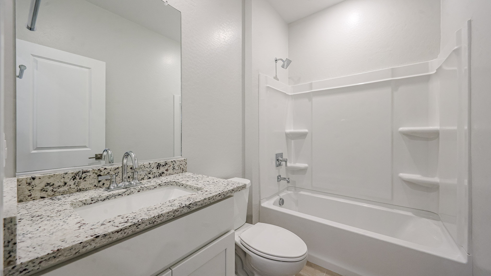 A bathroom with a marble countertop.