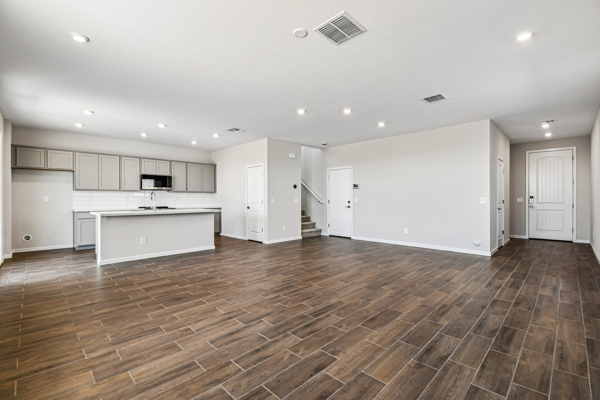 A large empty room with white cabinets.