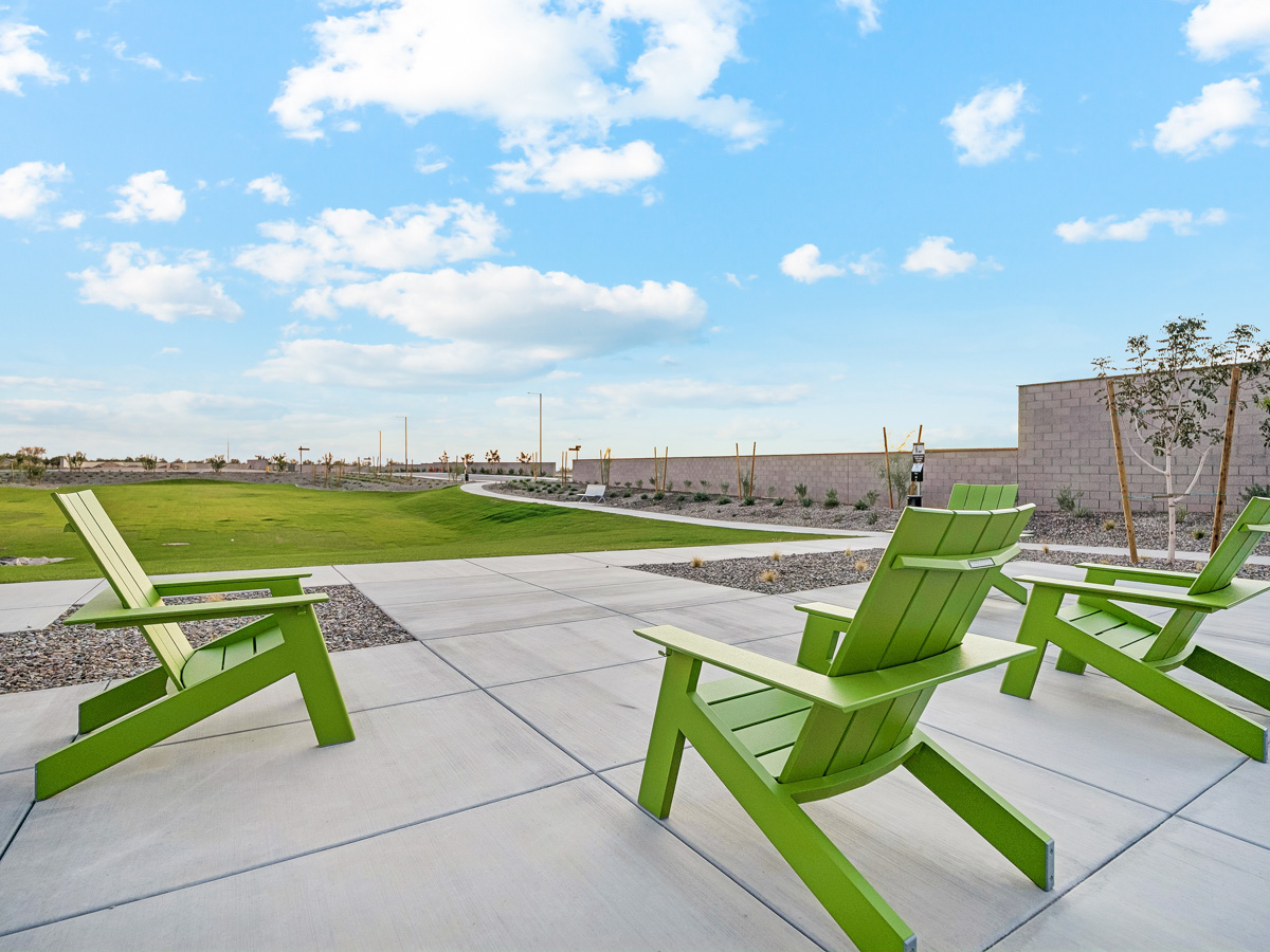 A group of green chairs on a patio.