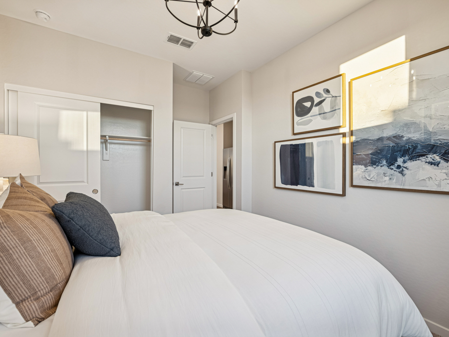 A bedroom with a bed and a lamp.