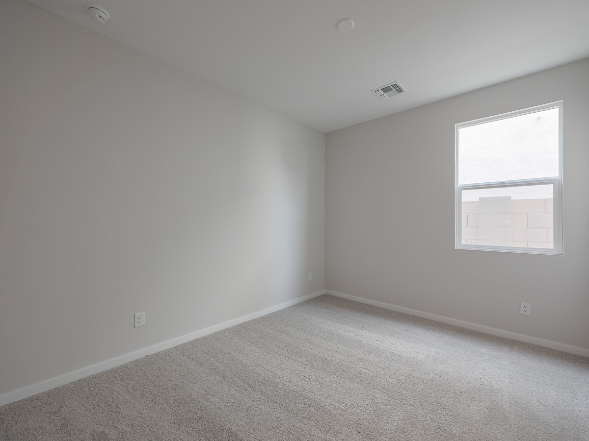 A room with a white wall and a window.