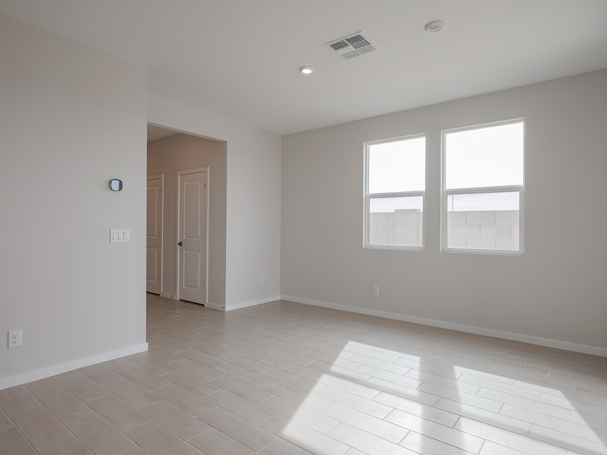 A room with white walls and a tile floor with a white door.