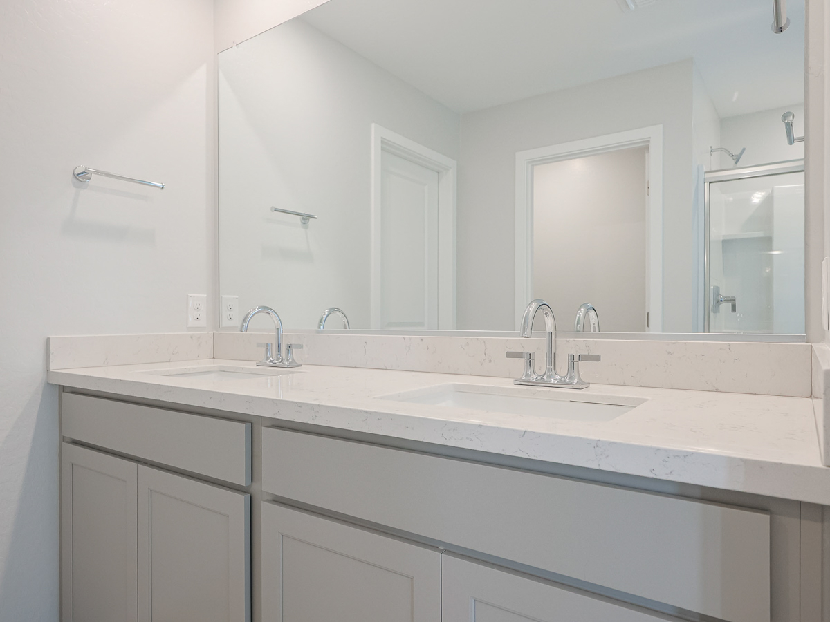 A bathroom with white cabinets.