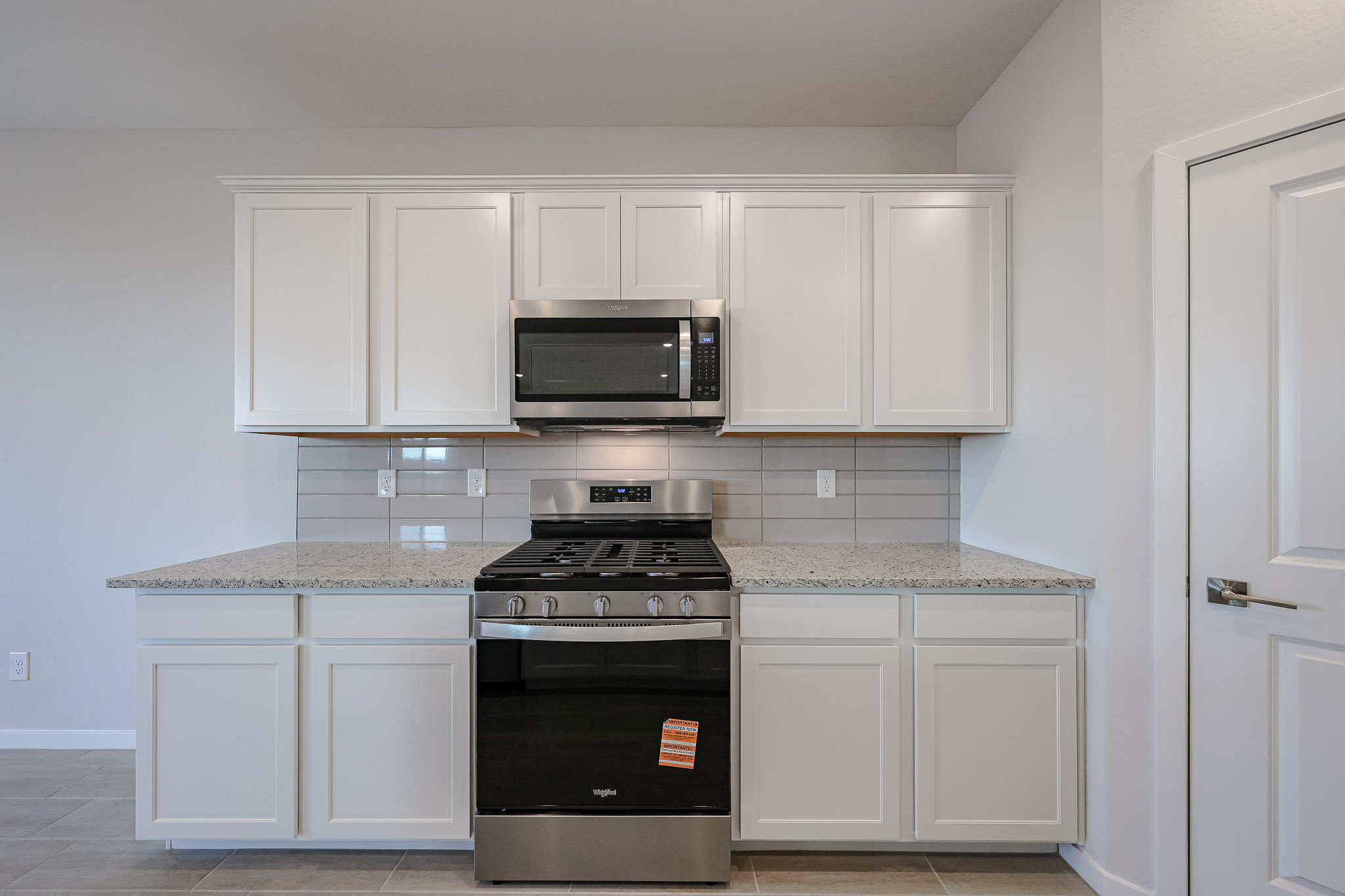 A kitchen with white cabinets.