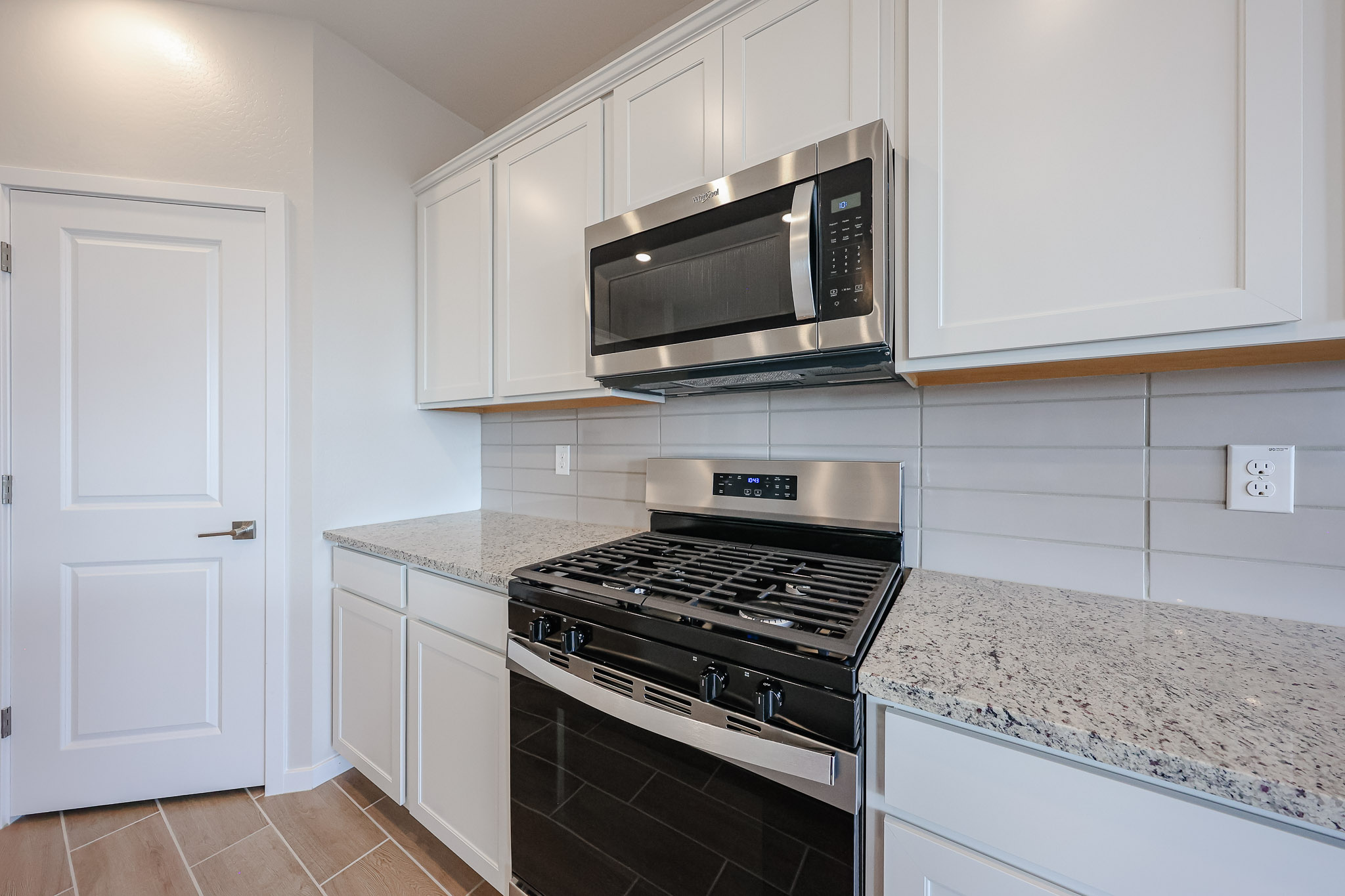 A kitchen with white cabinets.