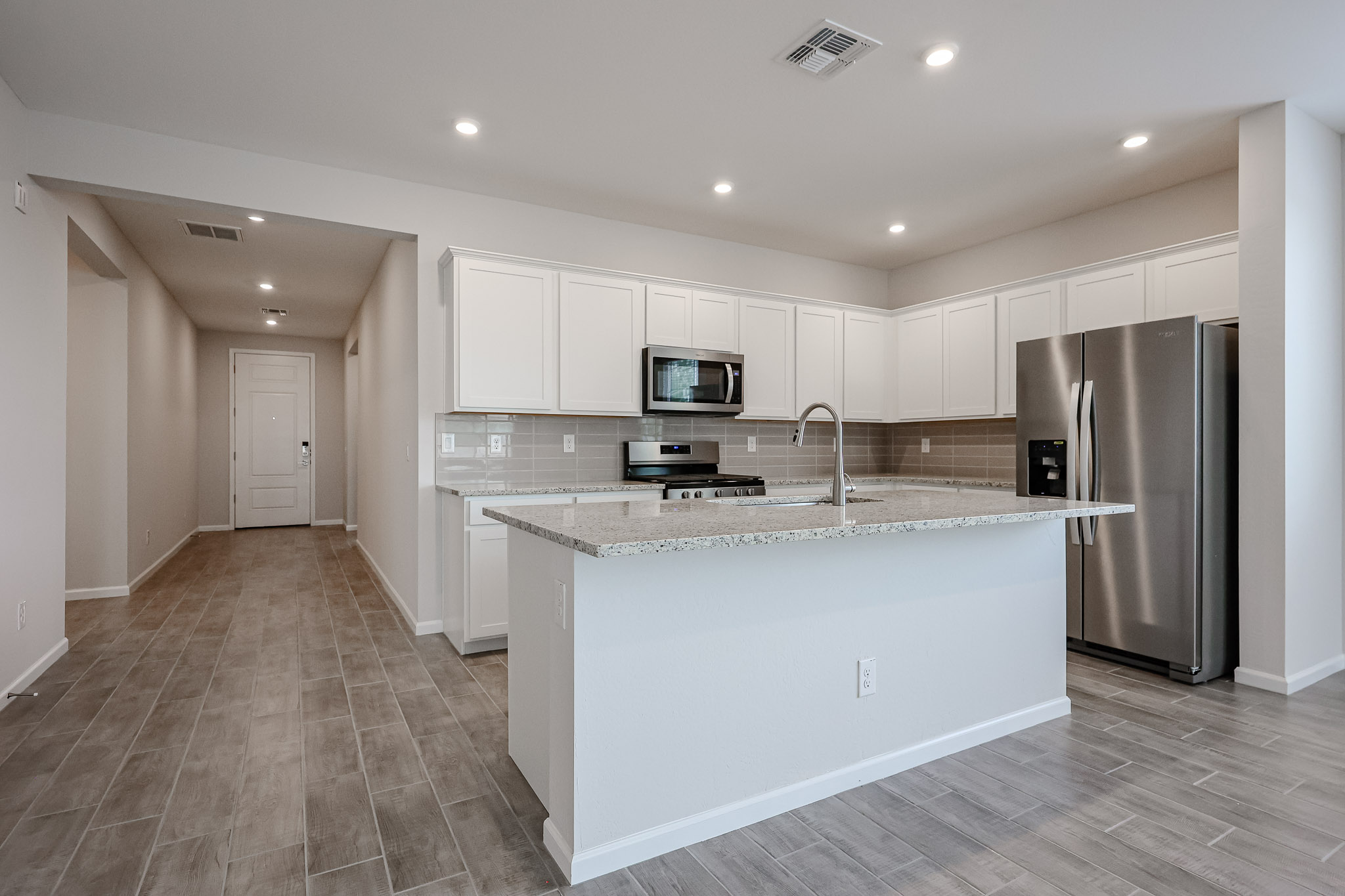 A kitchen with white cabinets.