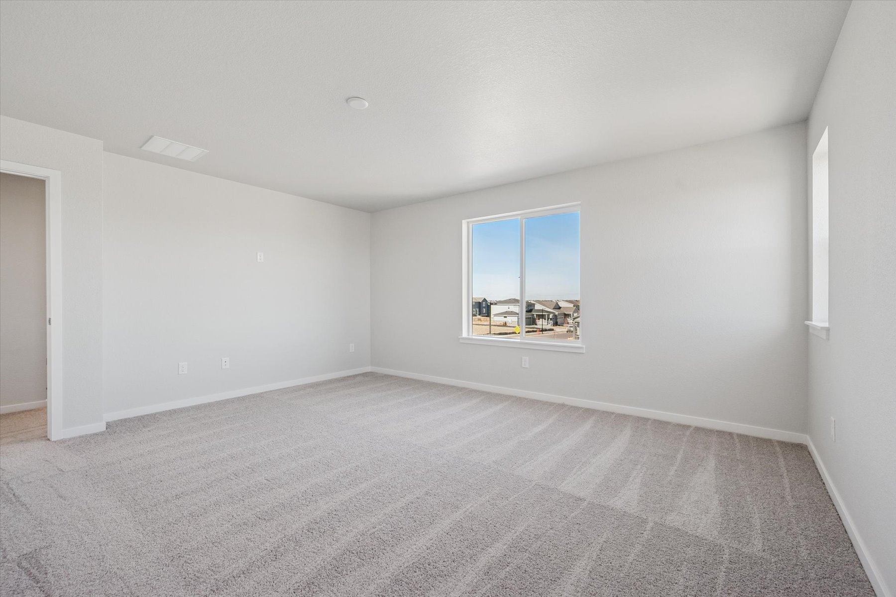 A room with a window and a carpet.