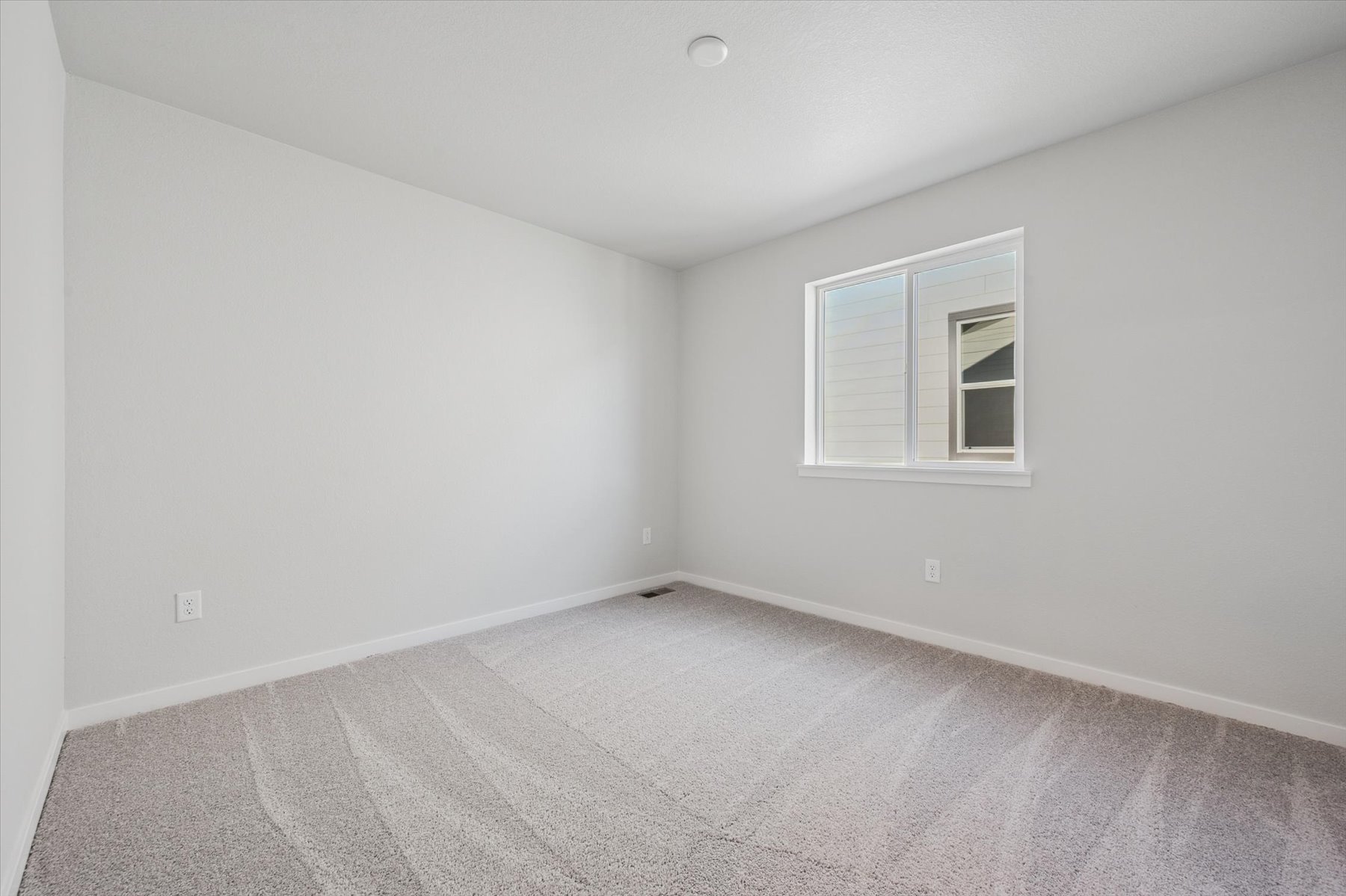 A room with a window and a carpet.