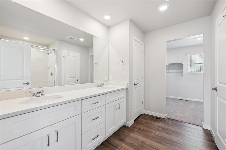 A bathroom with white cabinets.