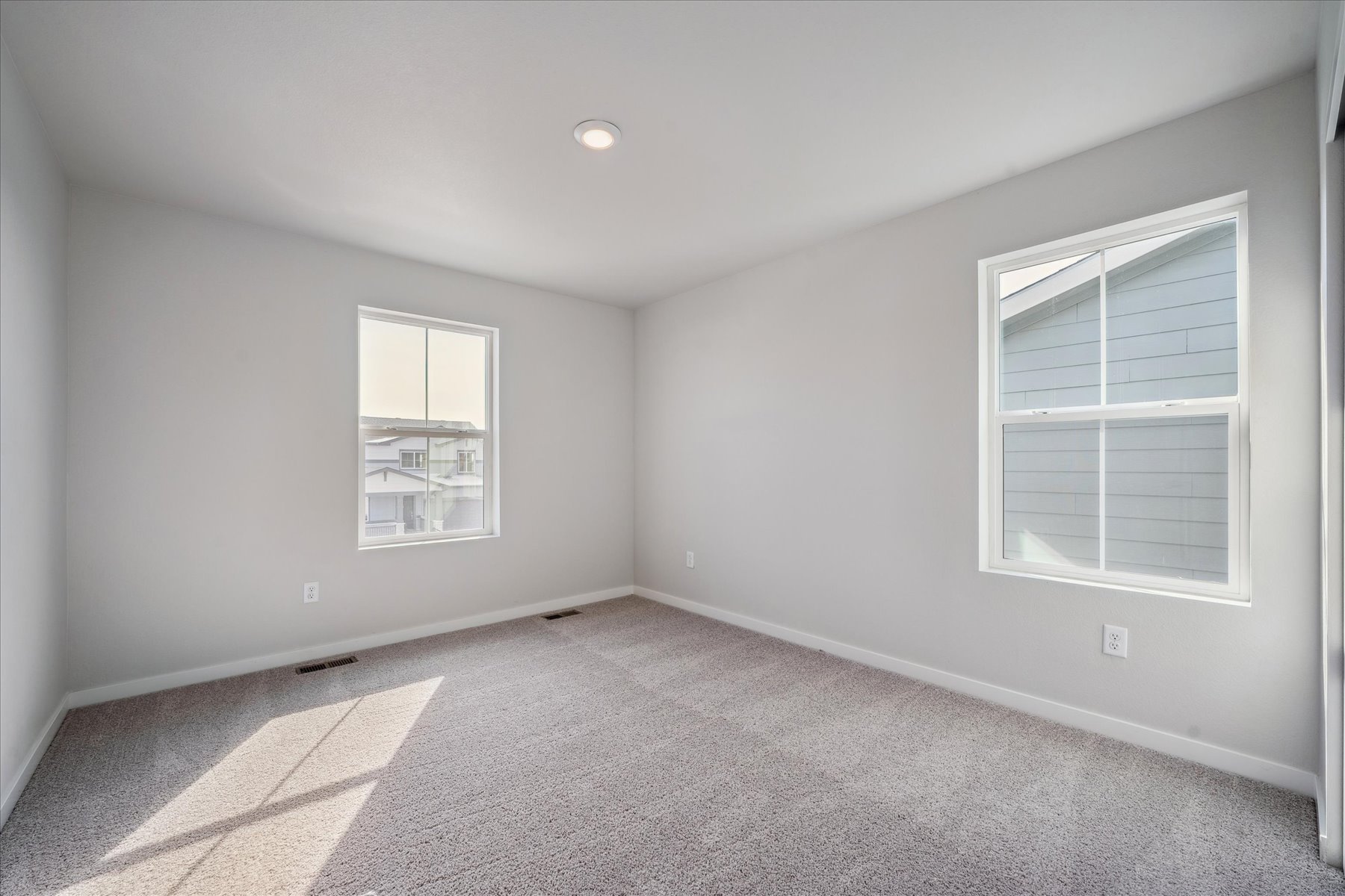 A room with a window and a rug.