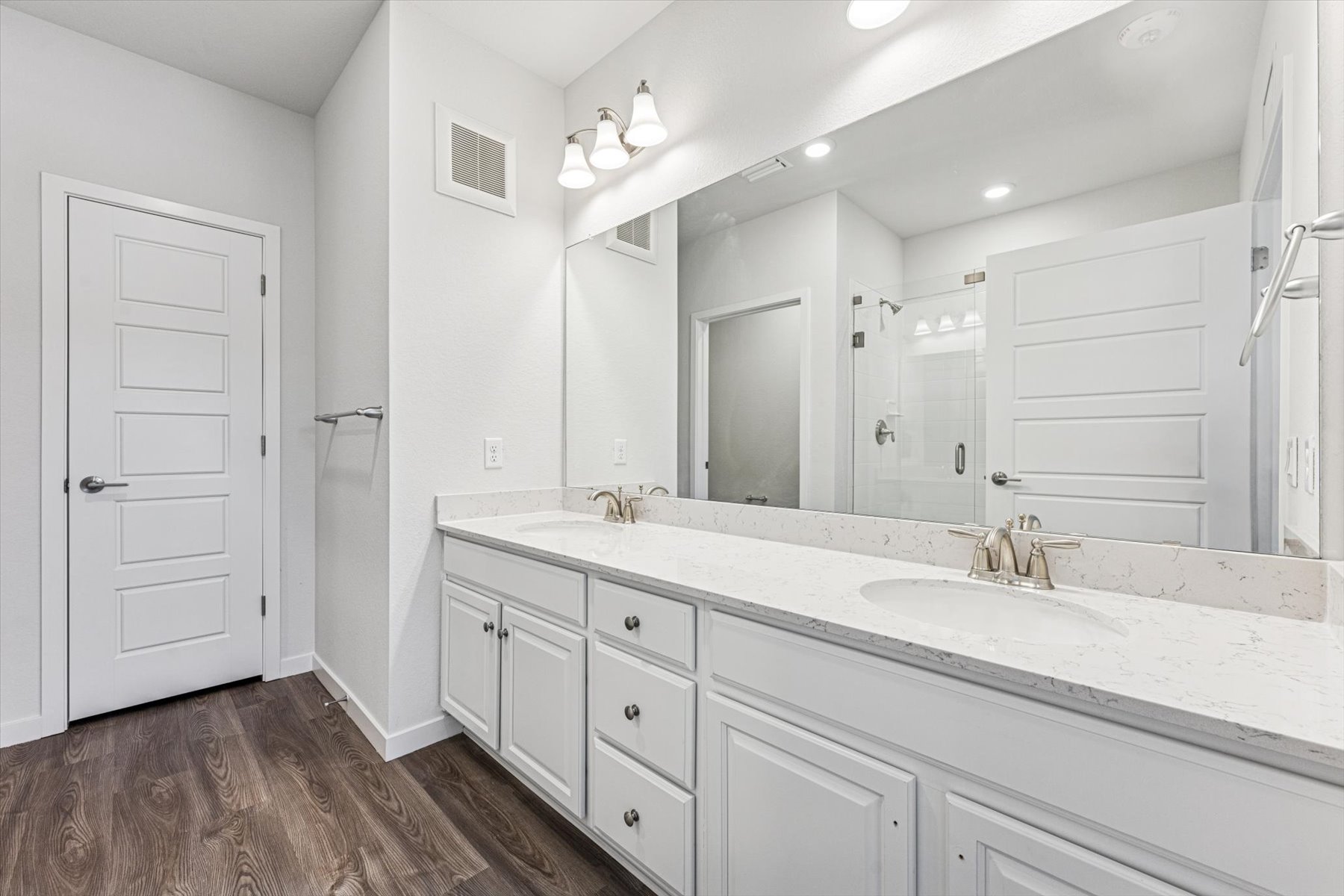 A bathroom with white cabinets.