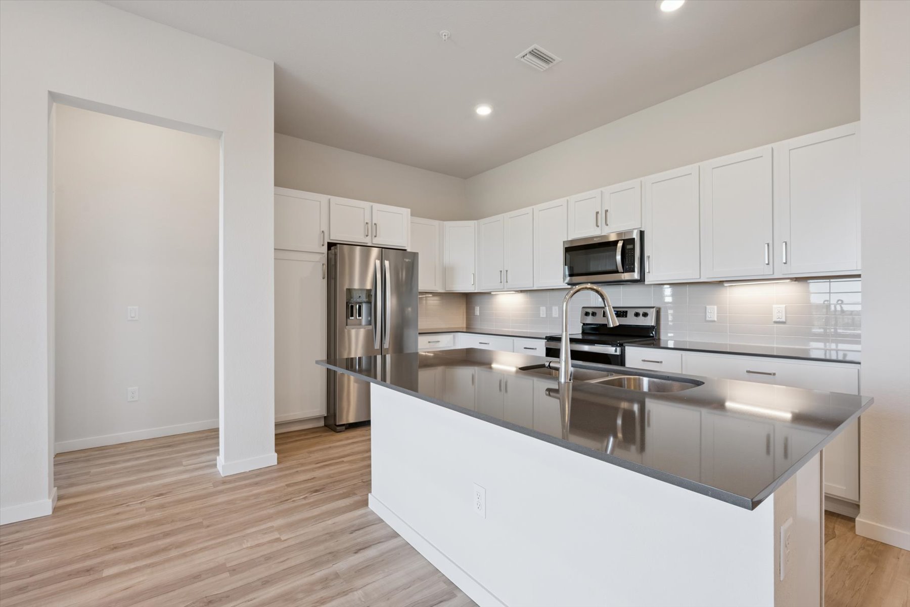 A kitchen with white cabinets.