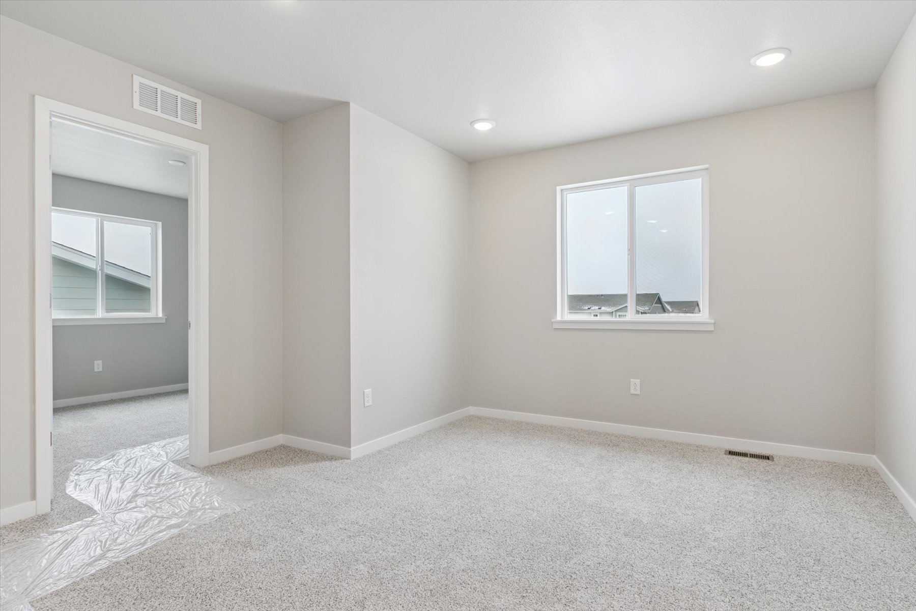 A room with a rug and a window.