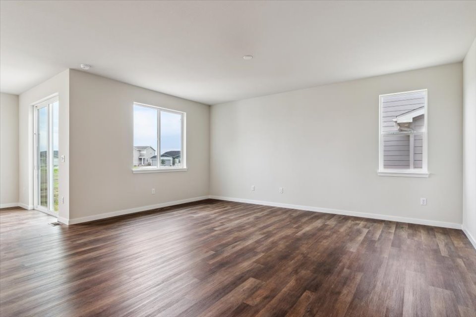 A room with a wood floor and windows.