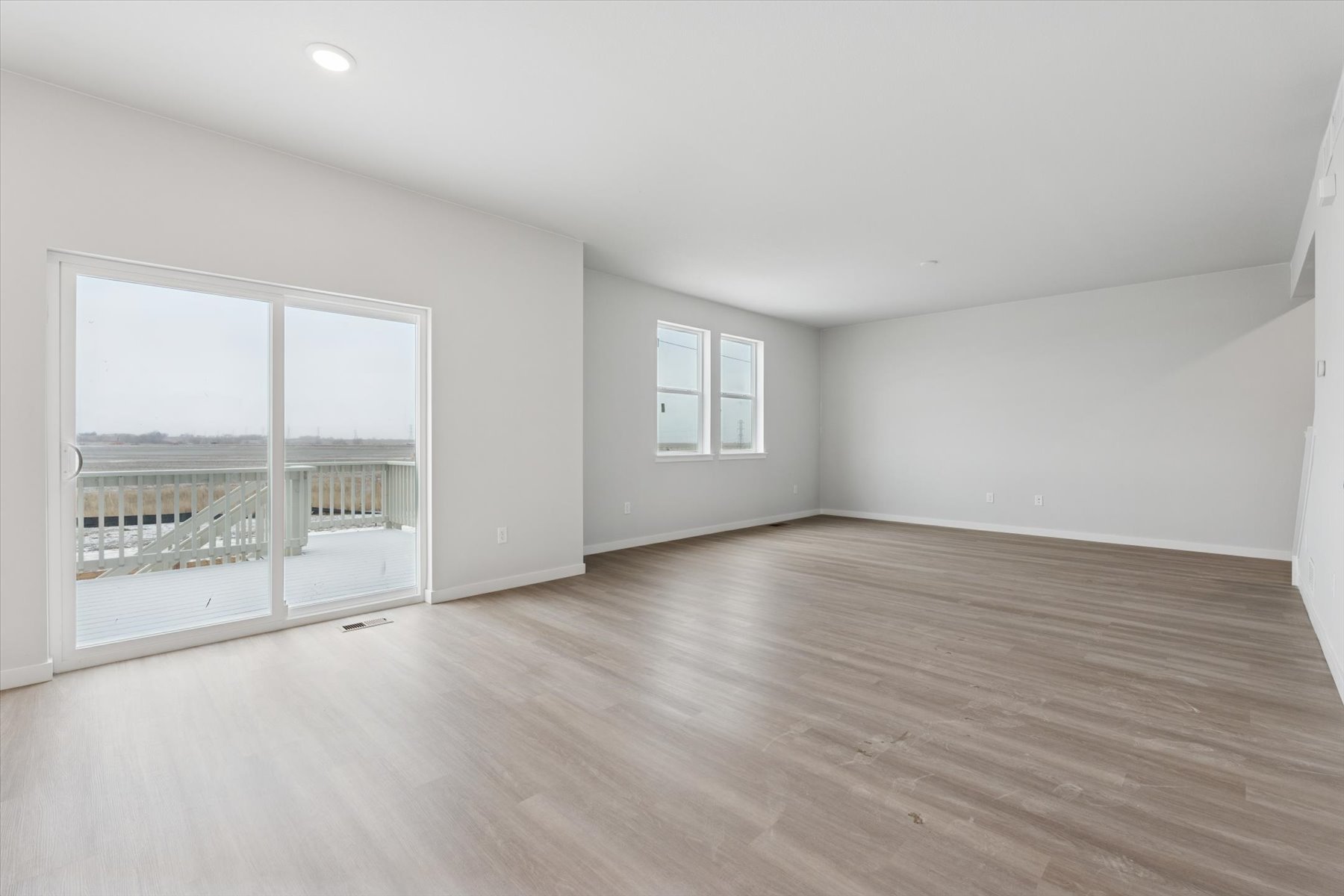 A room with a wood floor and windows.