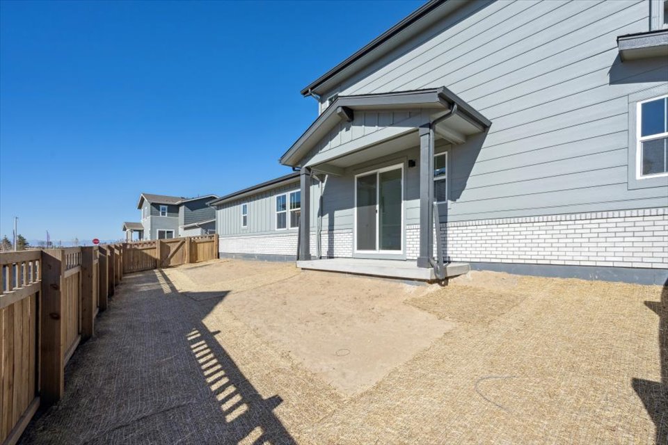 A dirt road next to a house.