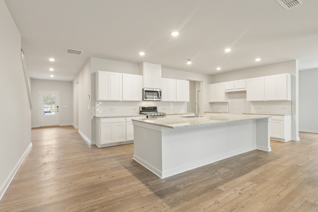 A kitchen with white cabinets.