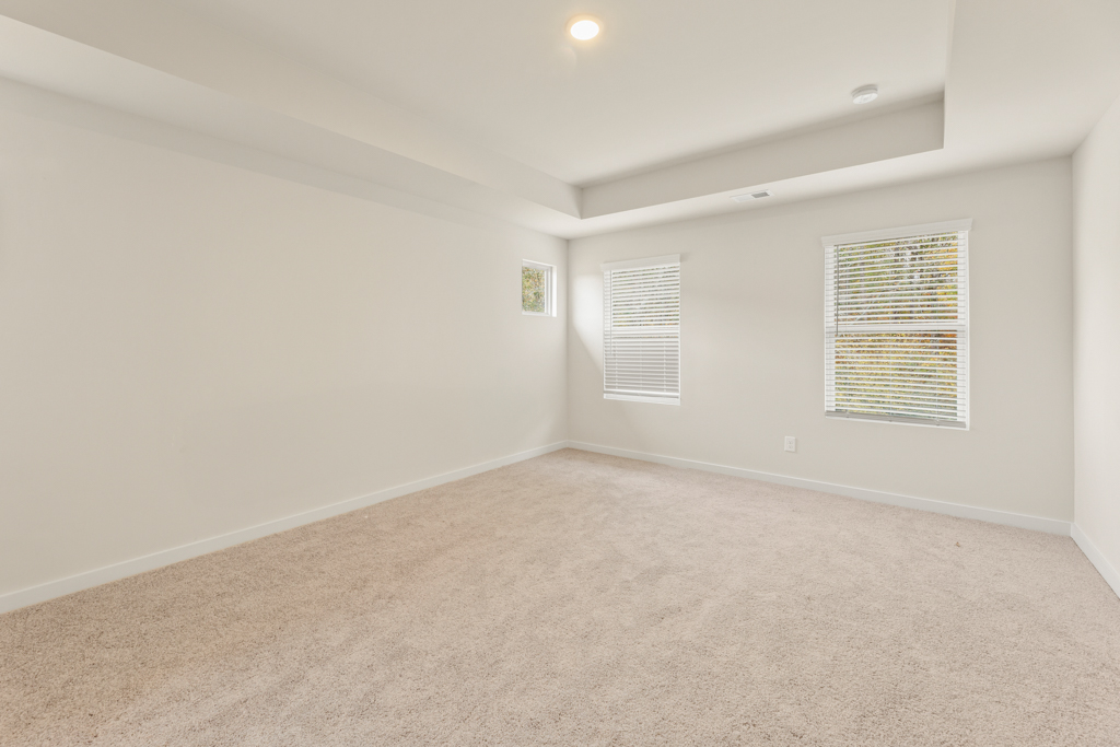 A room with a carpet and a window.