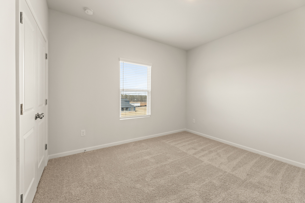 A room with a window and a carpet.