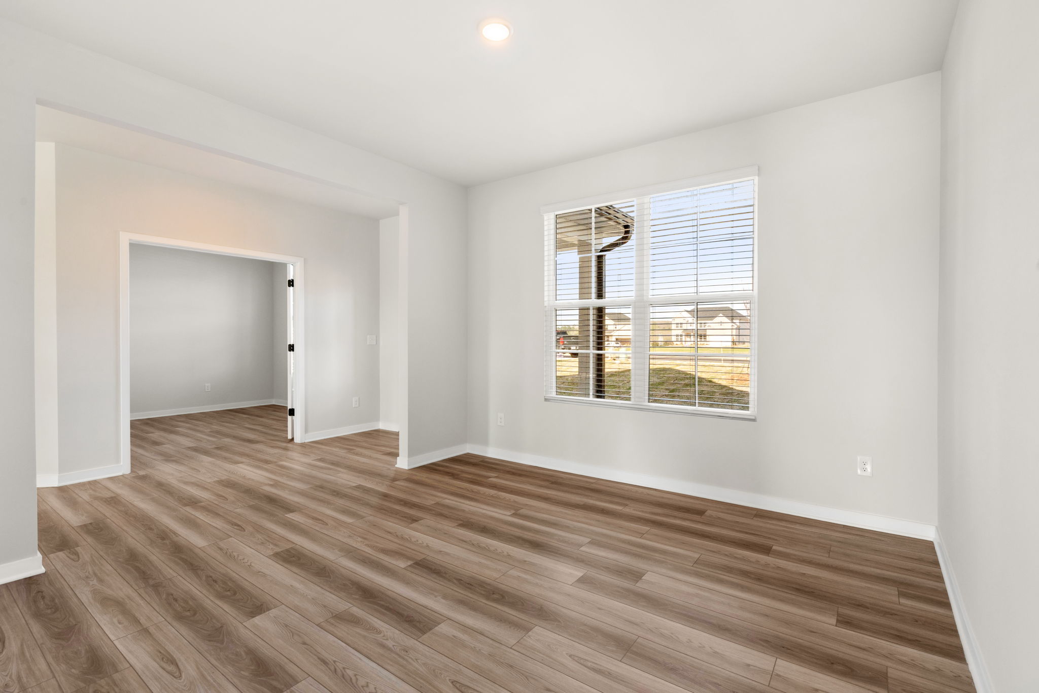 A room with a wood floor and a window.