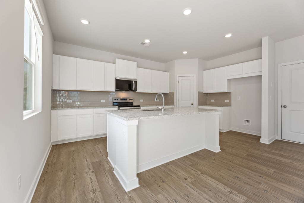 A kitchen with white cabinets.