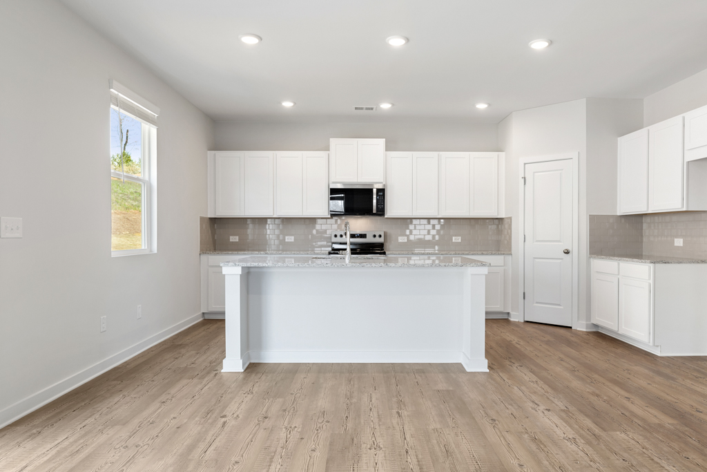 A kitchen with white cabinets.