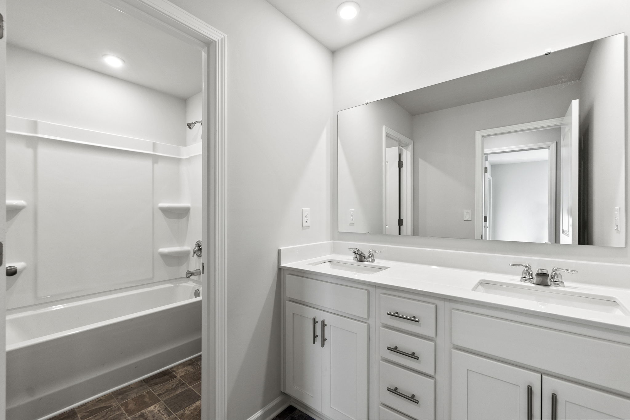 A bathroom with a tub sink and mirror.