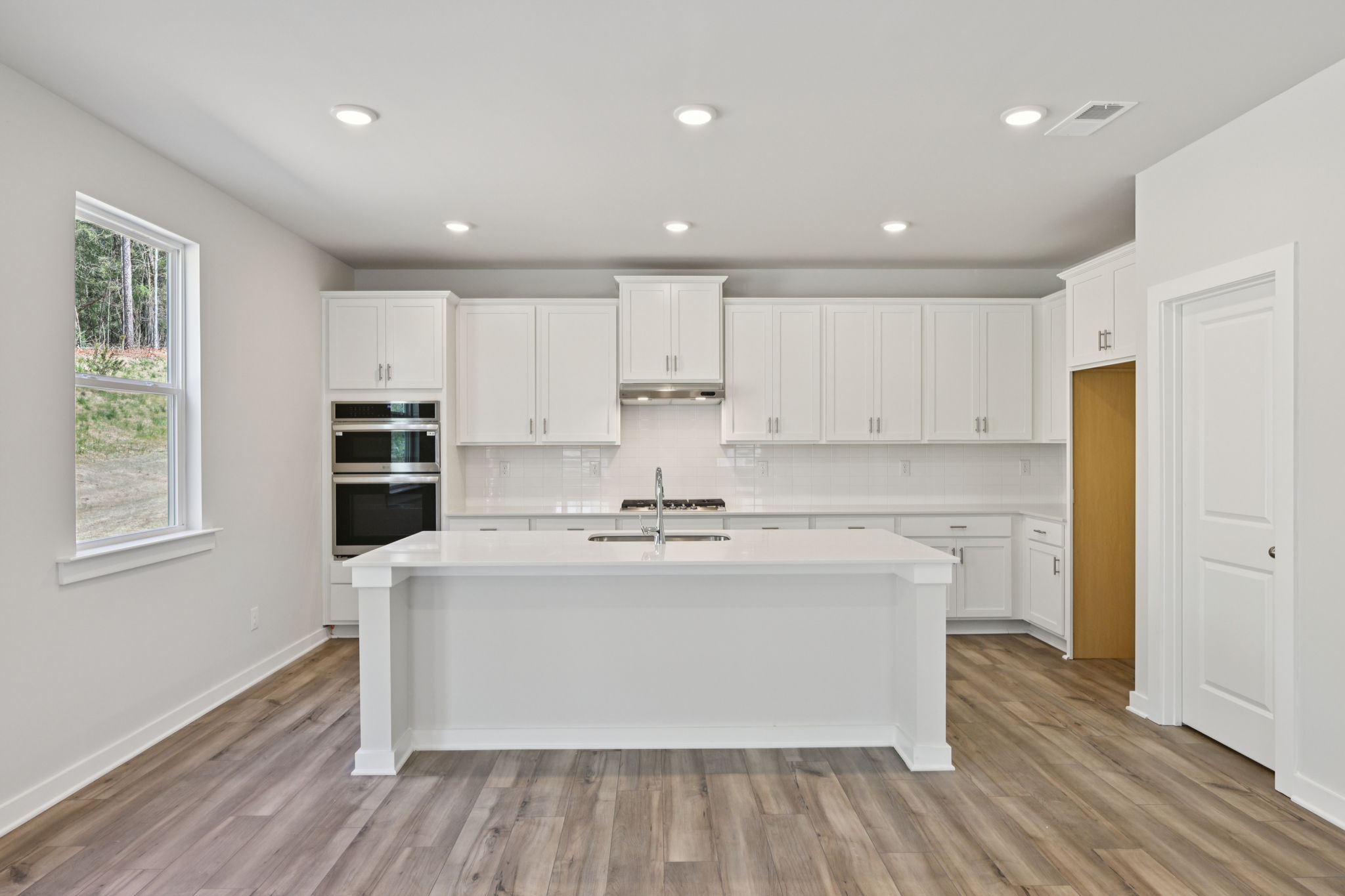 A kitchen with white cabinets.