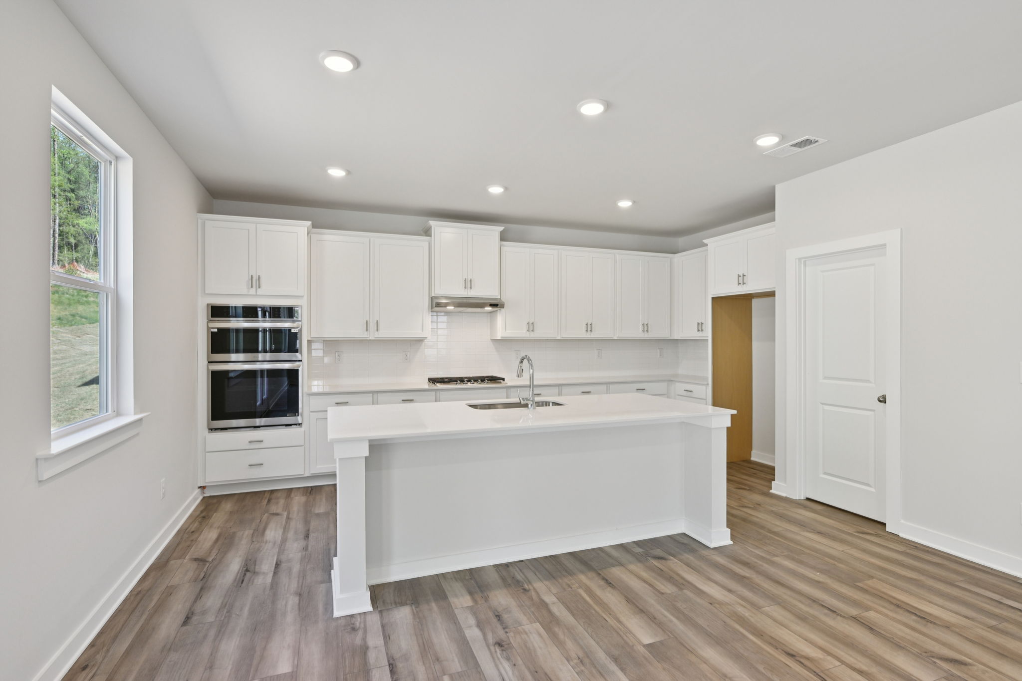 A kitchen with white cabinets.