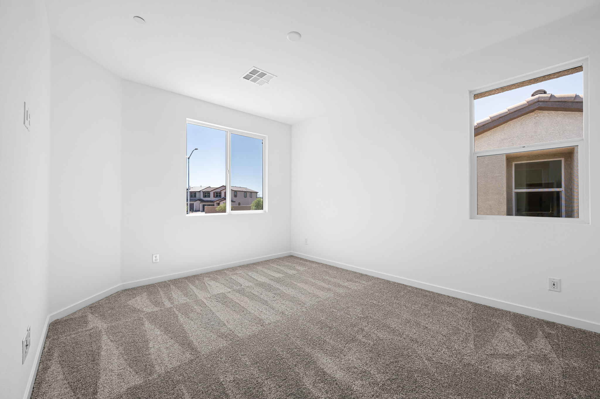 A room with a carpet and windows.