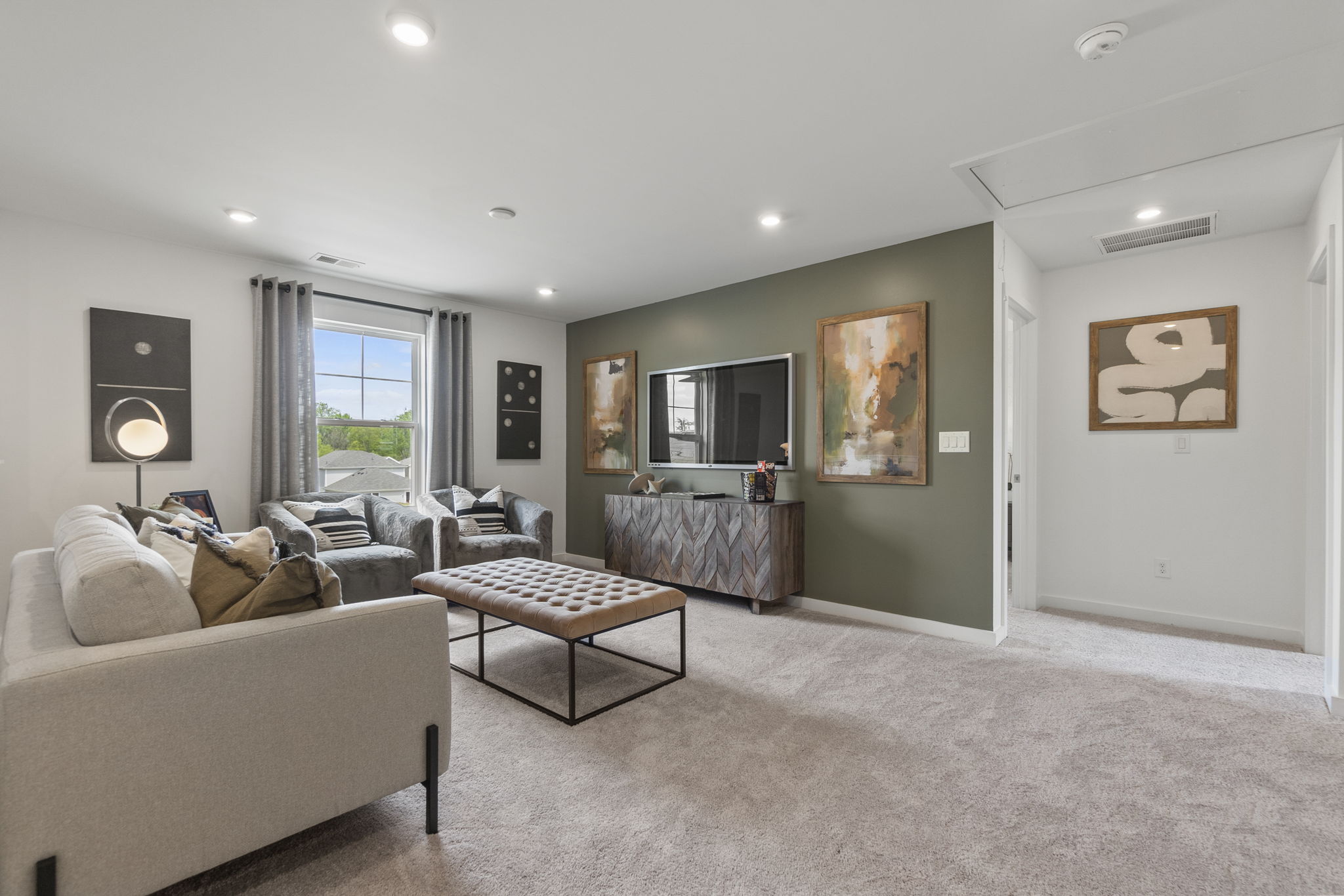 A living room with a large tv and couches.