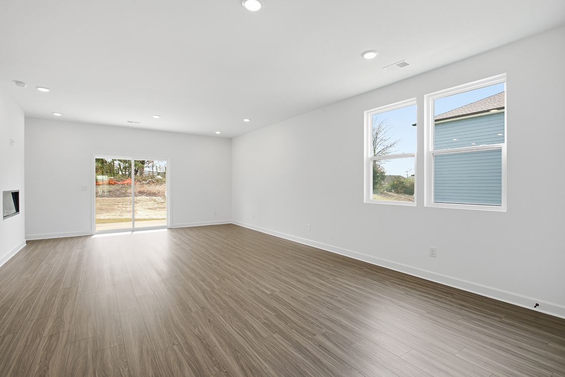 A room with a wood floor and windows.