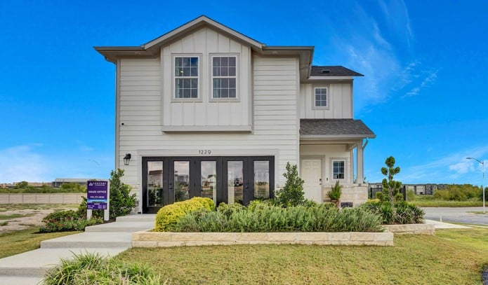 A white house with a sign in front of it.