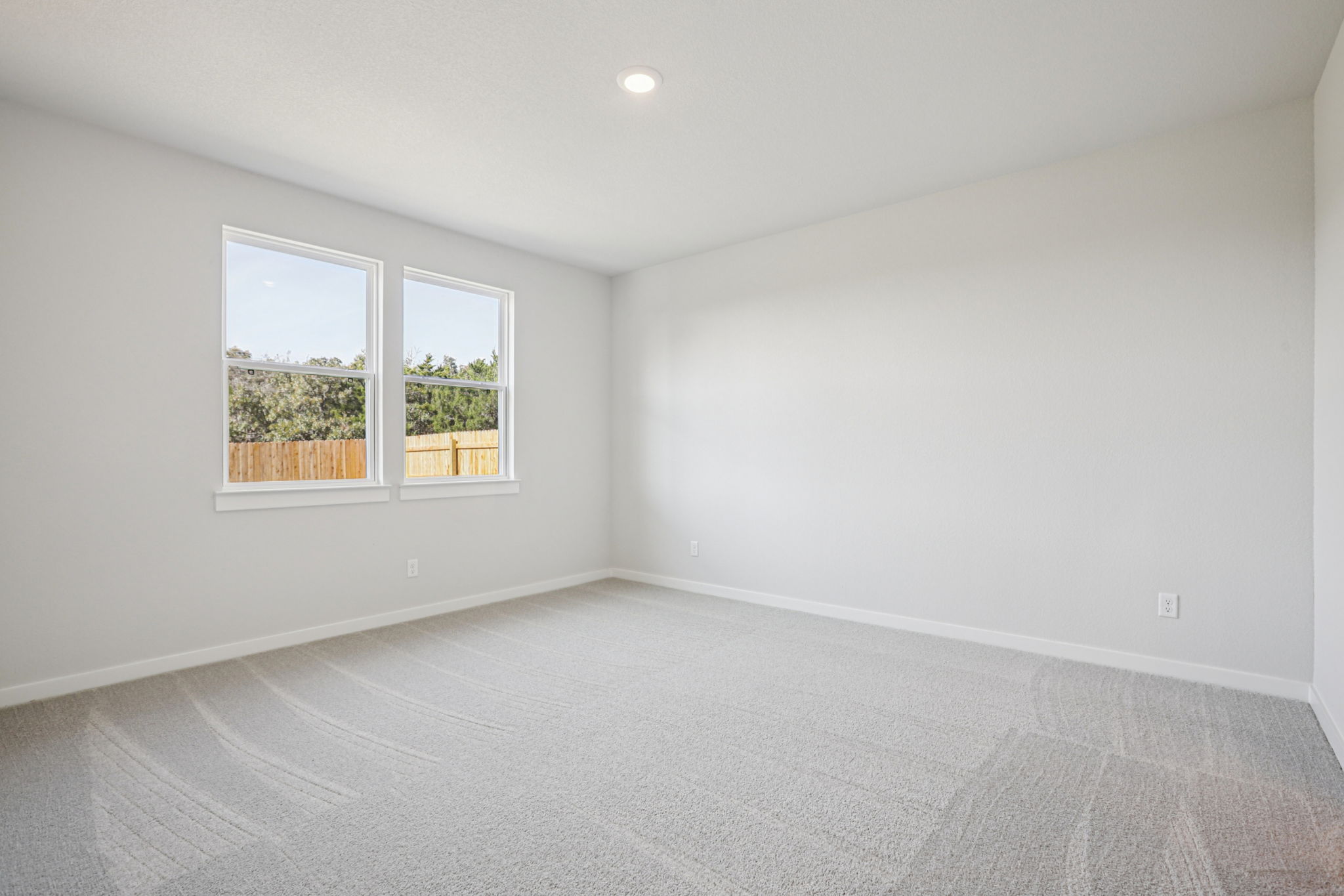 A room with a window and a white wall.