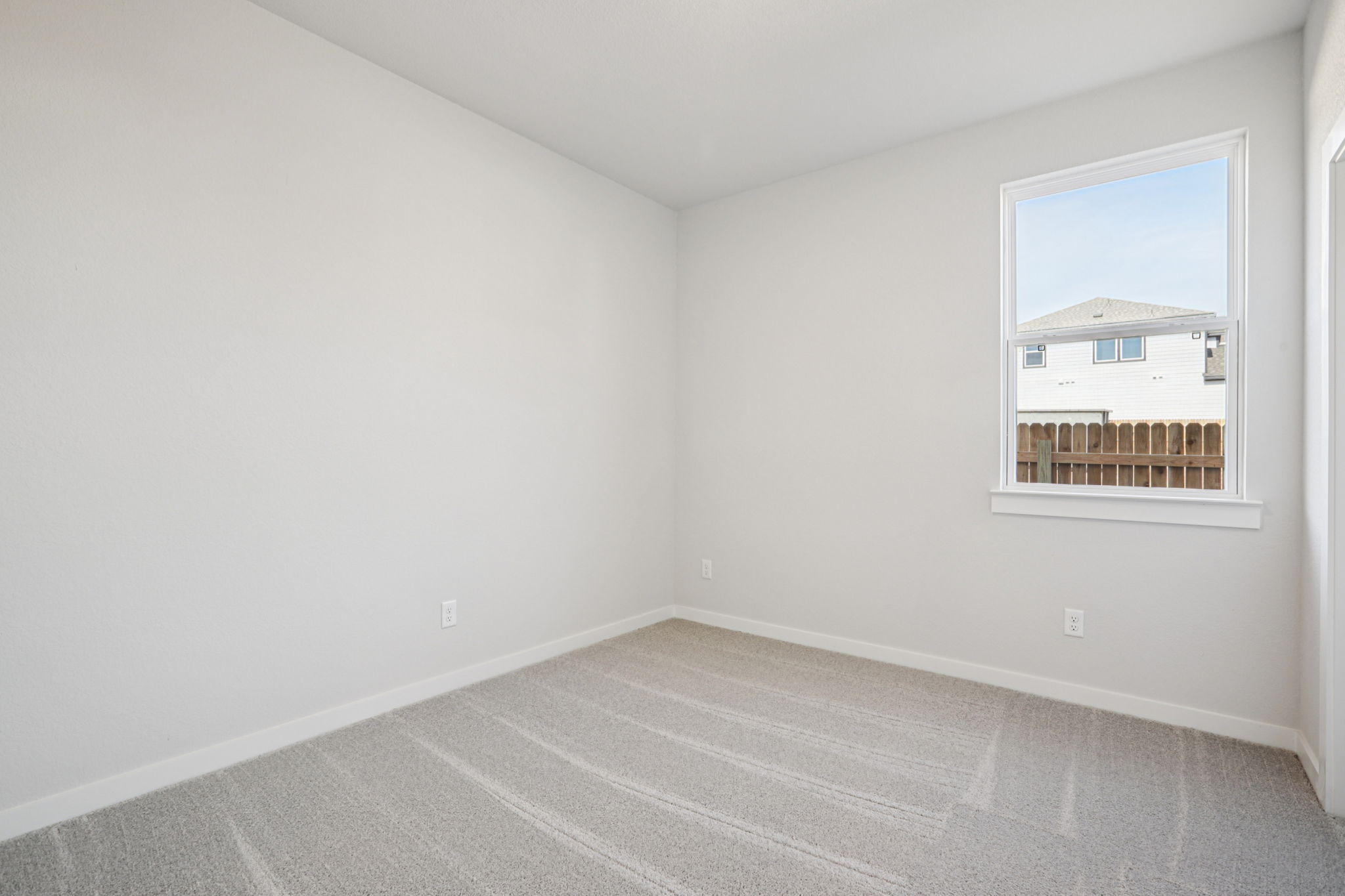 A room with a window and a rug.