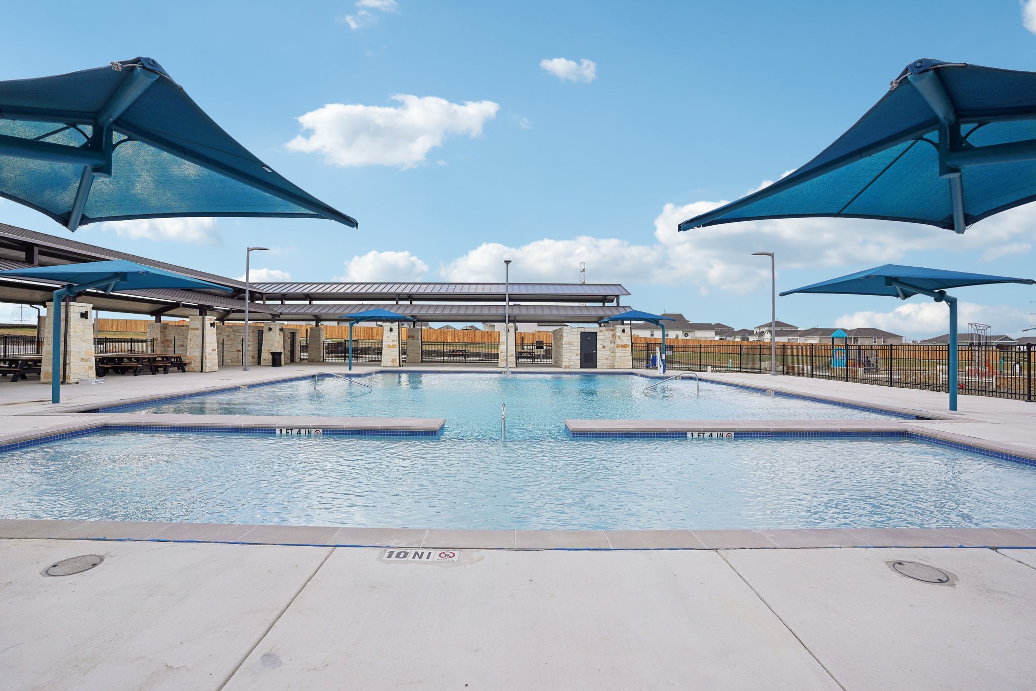 A pool with a building in the background.