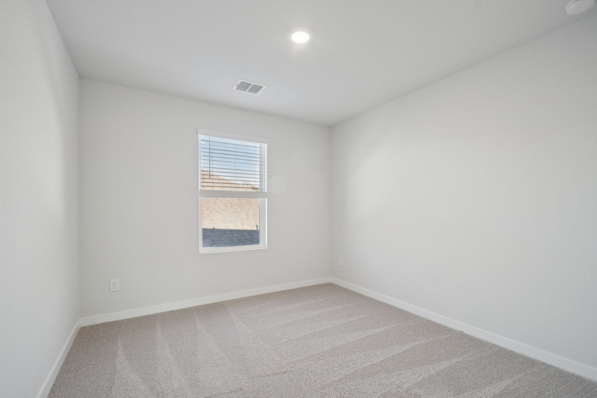 A room with a window and a carpet.