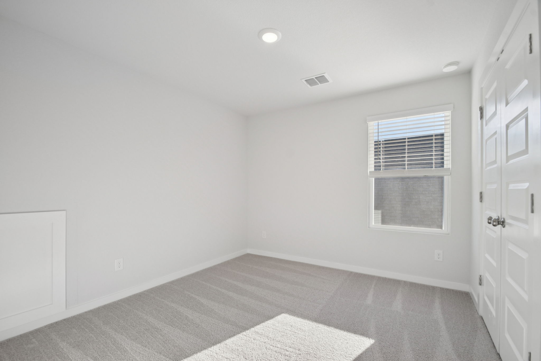 A room with white walls and a rug.
