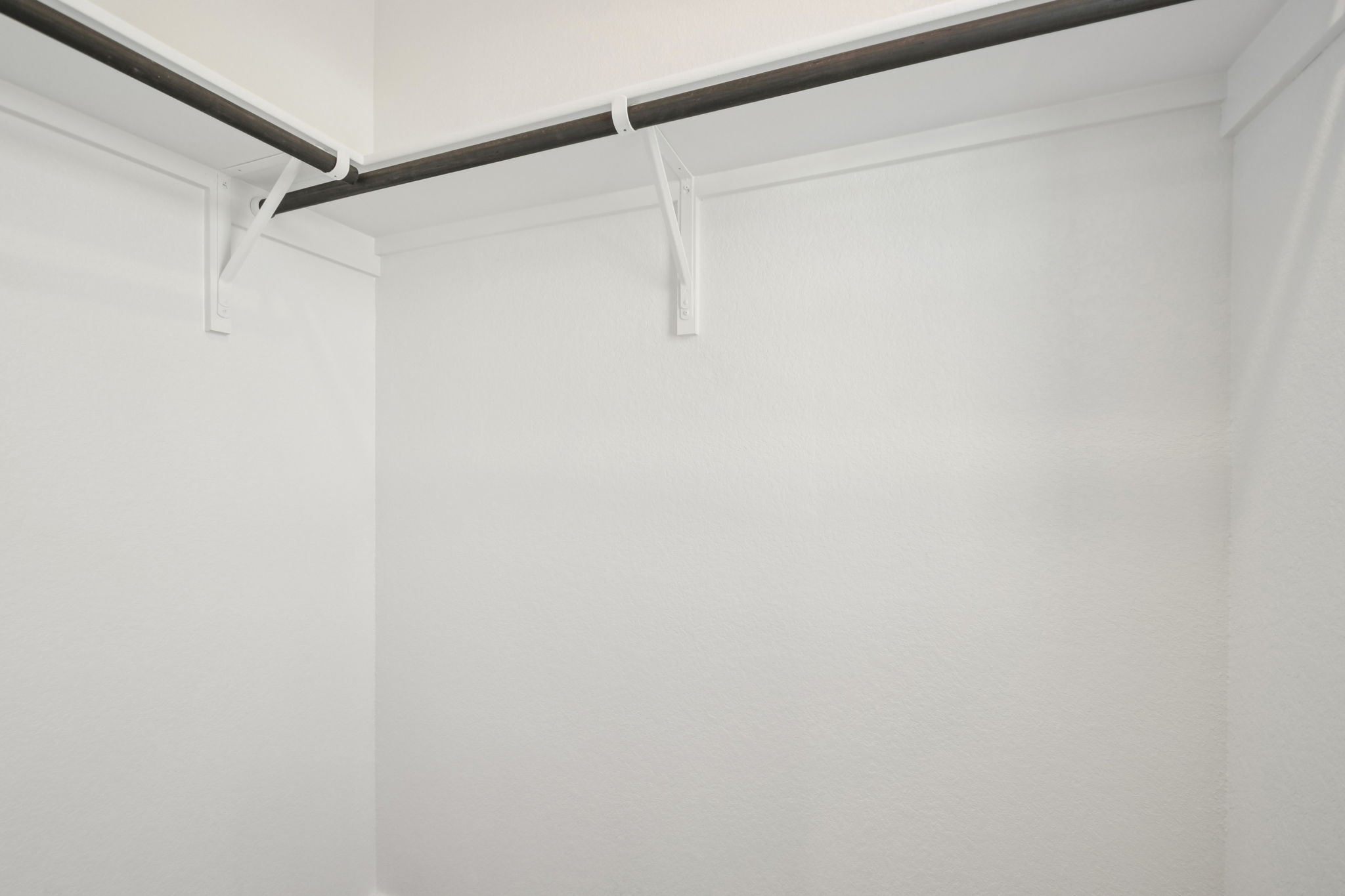 A white wall with a metal bar.